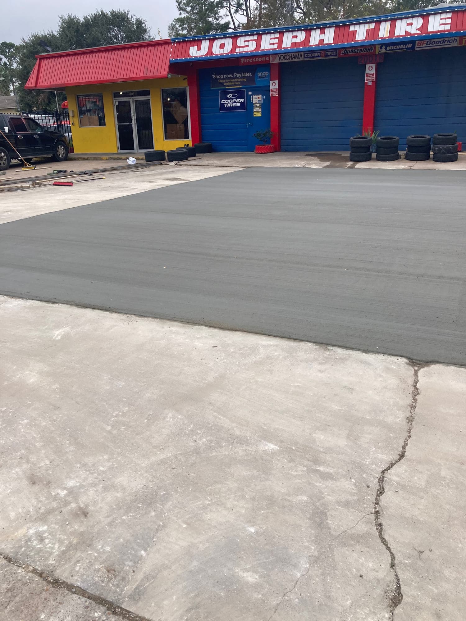 Finished commercial concrete drive approach with a uniform broom finish in front of an auto service building.
