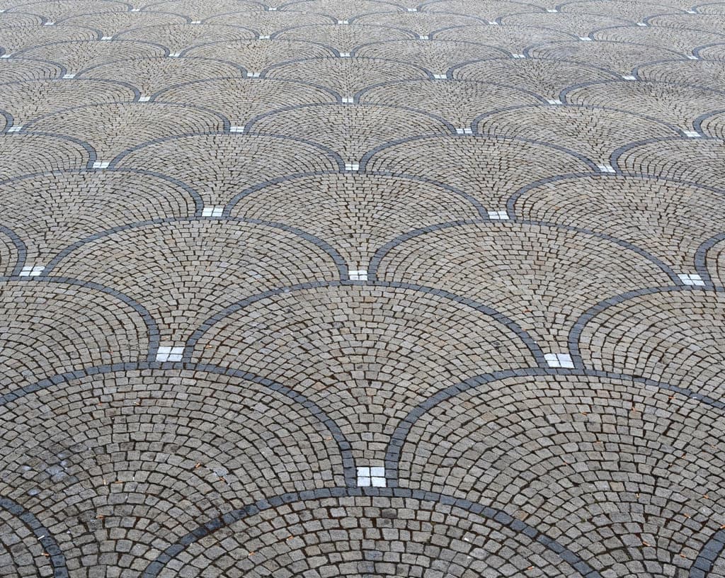 A fan-pattern stamped concrete surface laid in an interlocking arc design.